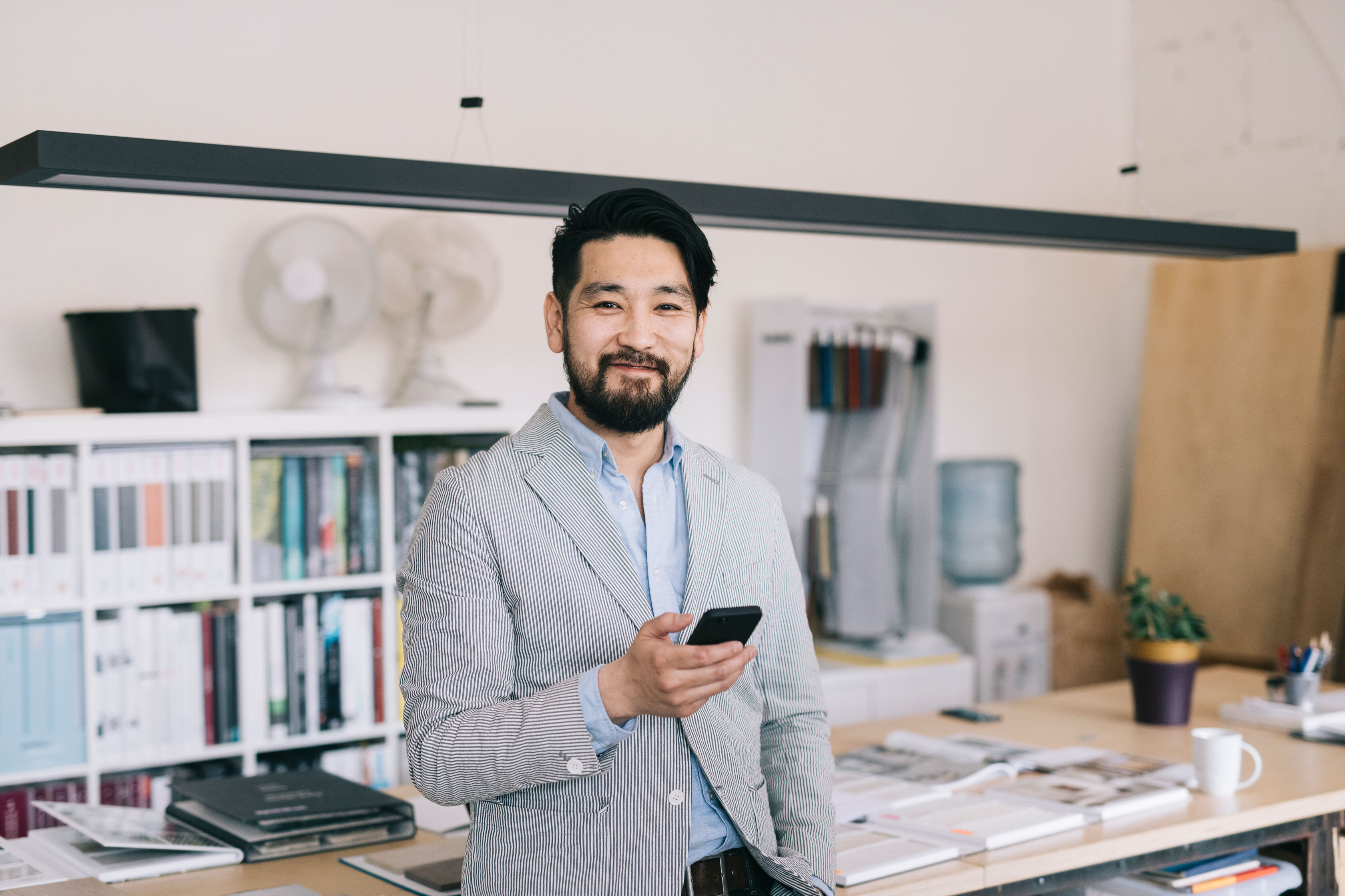 Man holding cellphone phone in front of him, looking at camera